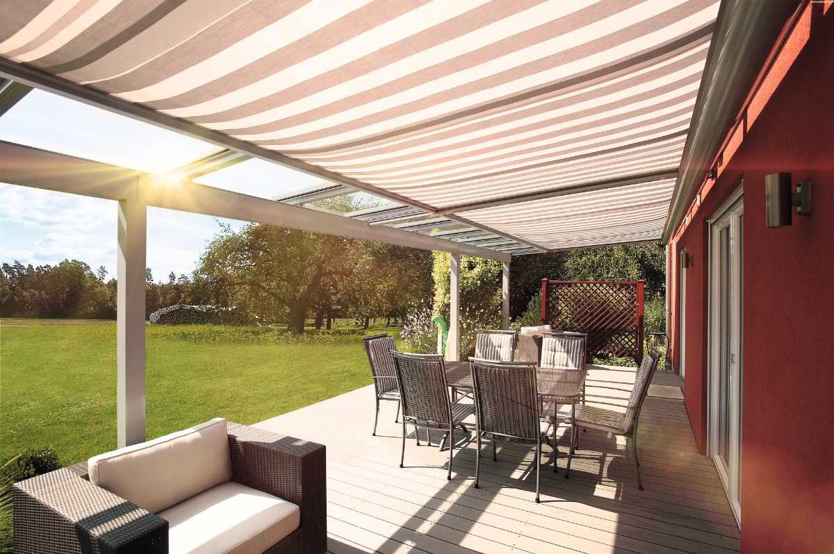 Terrasse mit Überdachung und Unterdachmarkise Sonnendurchflutete Terrasse mit Markise und Gartenmöbeln